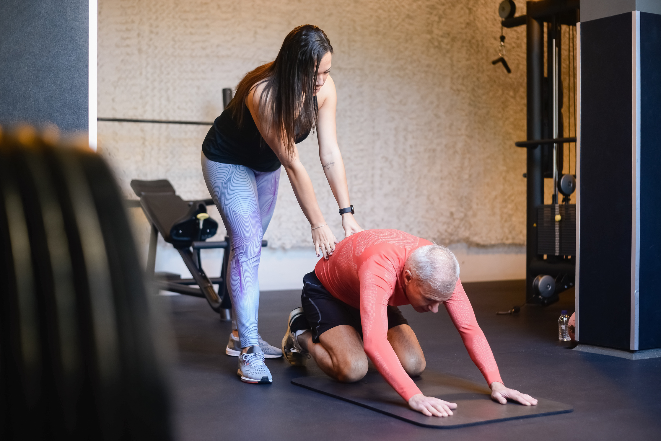 A Personal Trainer Helping an Elderly Man Stretch His Body
